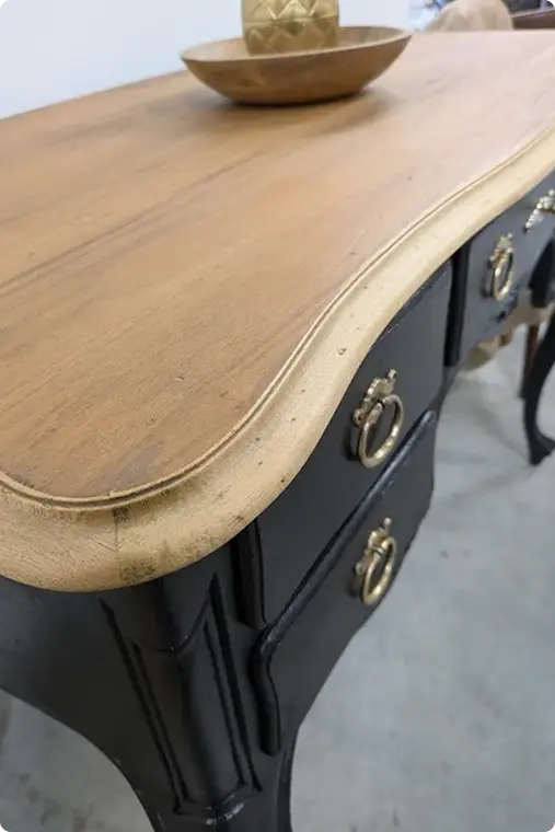 Bureau ancien orné avec un bol décoratif, mettant en valeur l’élégance du mobilier vintage.
