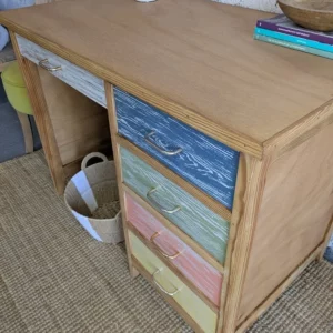 Bureau vintage en bois restauré avec tiroirs multicolores et finition patinée, style bohème et éclectique